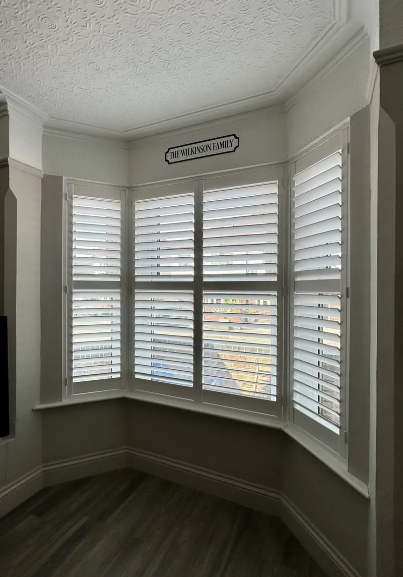 White plantation shutters fitted in a bay window